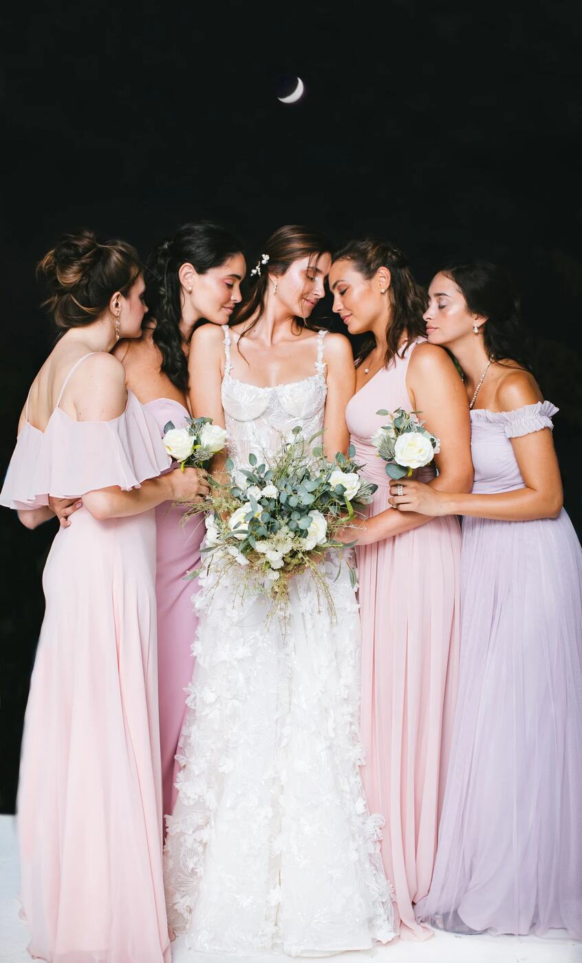 Bride surrounded by bridesmaids beneath a crescent moon